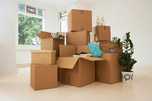 Removalists carrying boxes through a Shepherds Bush residential property